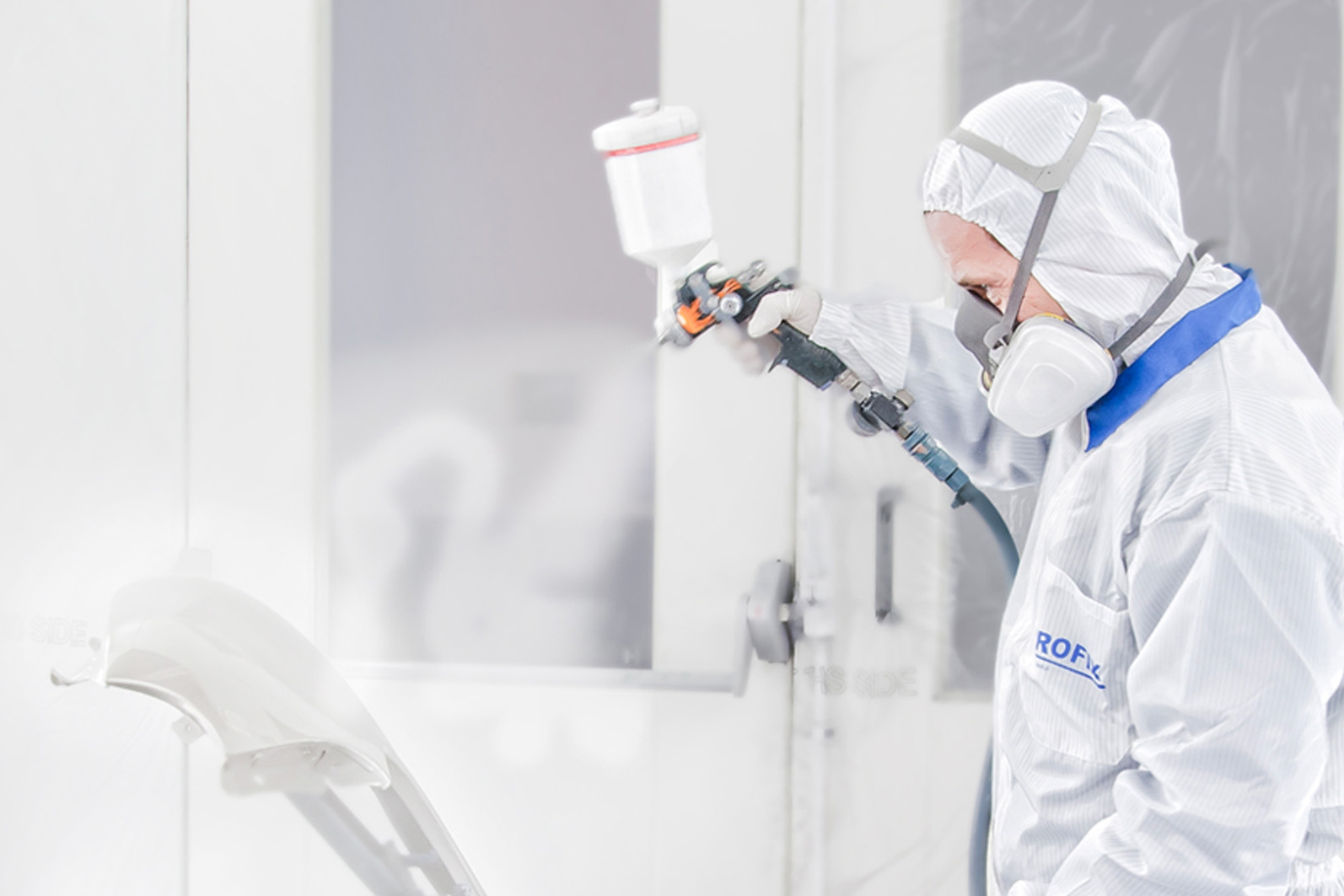 lakiernik w kombinezonie Profix lakieruje na biało